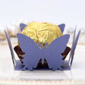 Macro shot of purple laser-cut butterfly candy box with gold foil chocolate and pearl detail