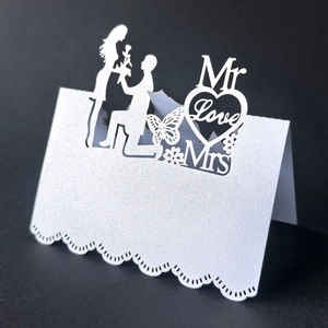 Macro detail of laser-cut wedding place card with Mr & Mrs silhouette and pearl finish