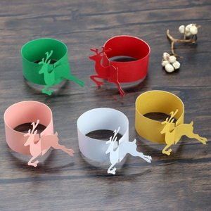 Close-up of pearl paper Christmas reindeer napkin rings in red, gold, and green colors