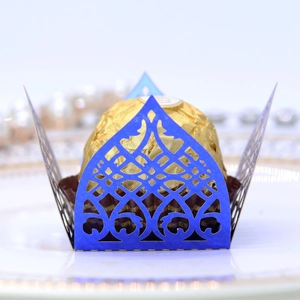 Detailed laser-cut blue lace paper wrapper with intricate scroll patterns for chocolates