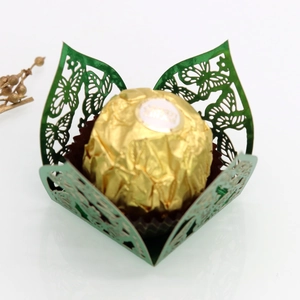 Detail of laser-cut green butterfly chocolate holder with metallic finish for parties