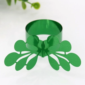 Close-up of sparkling green iridescent paper napkin ring with hollow leaf pattern