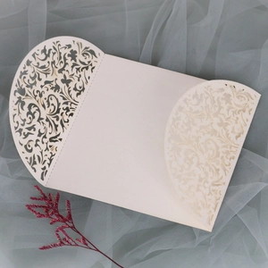 Détails de découpe laser florale sur invitation de mariage blanc cassé avec paillettes