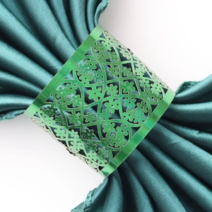 Macro shot of green metal napkin ring with intricate laser-cut lace floral patterns