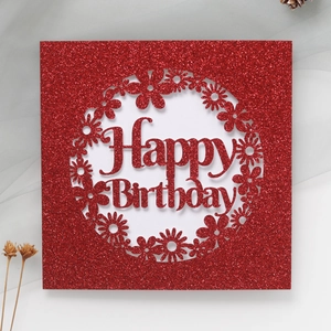 Détail d'une carte d'anniversaire rouge pailletée avec motif de marguerite découpé