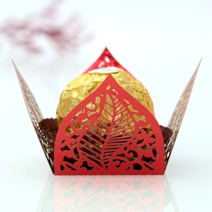 Macro shot of red laser-cut hollow leaf chocolate wrapper with elegant vine patterns