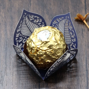 Detail showing dark blue laser-cut leaf pattern chocolate wrapper on dark wood