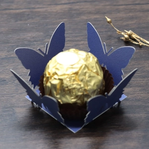 Detailed laser-cut dark blue butterfly candy holder with gold chocolate on wood