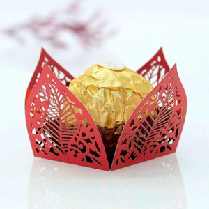 Detail of red laser-cut leaf pattern candy box with a gold chocolate inside