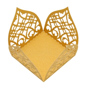 Macro detail of laser-cut vine patterns on a golden glitter gift box for chocolate