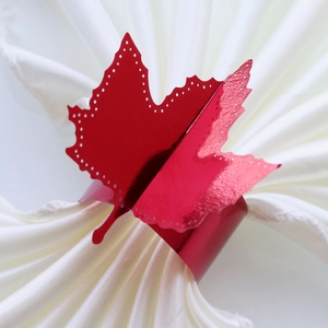 Glossy red maple leaf napkin ring with cutout dots for elegant autumn table decor