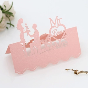 Macro detail of laser-cut pink wedding place card with Mr Love Mrs romantic design