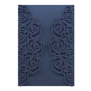 Macro detail of laser-cut rose patterns on pearlescent navy blue wedding invitation cards