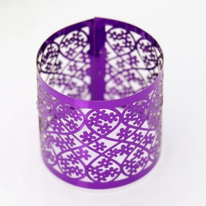 Macro view of purple laser-cut cupcake wrapper with floral and heart patterns