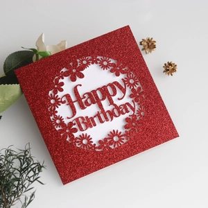 Vue détaillée de la carte d'anniversaire rouge pailletée avec fleurs découpées au laser