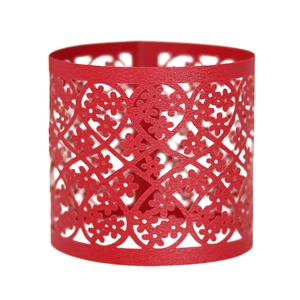 Close-up of red laser-cut napkin ring with intricate lace heart and floral patterns