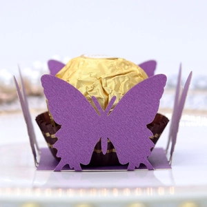 Macro view of laser-cut purple butterfly paper wrapper for chocolate candy decoration
