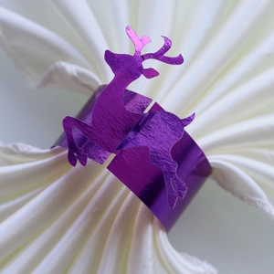 Detailed view of a purple mirrored reindeer napkin ring on a folded white cloth