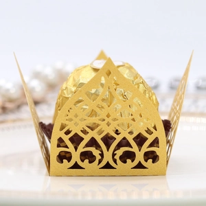 Detailed close-up of golden laser-cut hollow lace paper tray for chocolate decoration