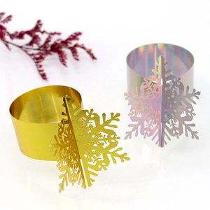 Detail view of laser-cut snowflake napkin ring with metallic gold and iridescent finish