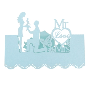 Detail of light blue laser-cut wedding place card with couple silhouette and butterfly