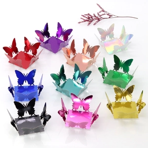 Close-up of laser-cut butterfly candy boxes in vibrant metallic colors on mirror surface