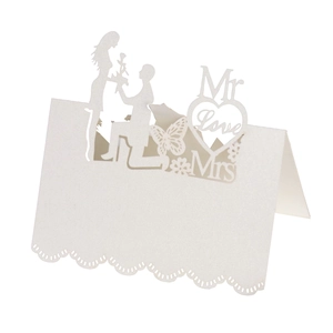 Elegant white laser-cut wedding place card featuring heart shapes and romantic silhouettes