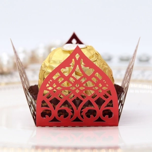 Macro shot of laser-cut red lace chocolate wrapper with elegant hollow-out pattern