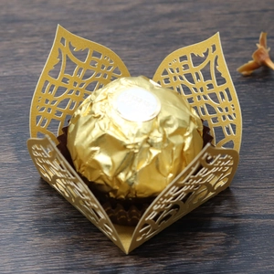 Detail of laser-cut gold hollow paper chocolate box with intricate geometric floral pattern