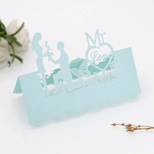 Macro detail of laser-cut wedding place card with Mr & Mrs text and glitter finish
