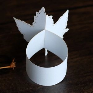 Macro shot of white laser-cut maple leaf paper napkin ring with detailed textures
