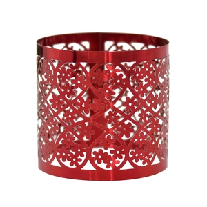 Macro detail of red metallic napkin ring featuring laser-cut floral patterns and glossy finish