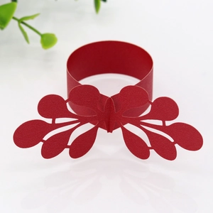 Detail of red laser-cut paper napkin ring with elegant hollowed butterfly pattern