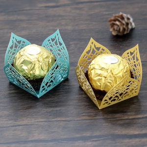 Detail of laser-cut hollow candy boxes in gold and blue for wedding party favors