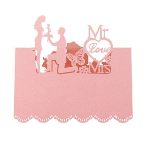 Detail of pink glitter laser-cut place card with romantic heart and proposal silhouettes