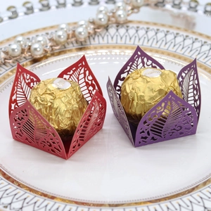 Detail of laser-cut hollow leaf patterns on red and purple paper candy gift boxes
