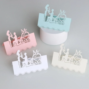 Detailed laser-cut wedding place cards featuring Mr Love Mrs hearts and butterfly motifs