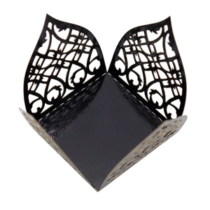 Macro shot of laser-cut black glossy wedding favor box with heart patterns