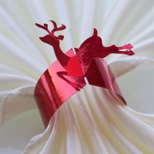 Close-up of red mirror finish reindeer paper napkin rings for Christmas table settings