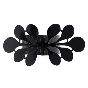 Close-up of black cutout floral napkin ring with intricate symmetrical metal patterns