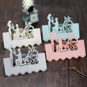 Detail of laser cut wedding place cards with Mr Love Mrs design and hollow butterfly pattern