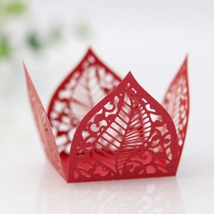 Macro detail of red laser-cut pearlescent paper candy box with intricate leaf patterns