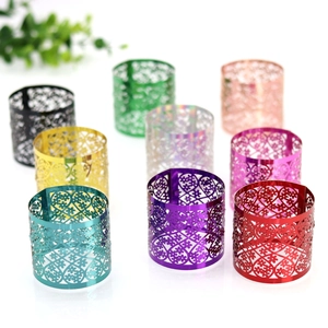 Close-up of laser-cut metal napkin rings with intricate floral and heart patterns