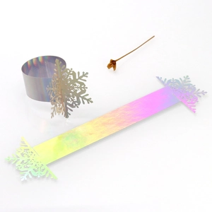 Macro view of laser-cut iridescent paper snowflake napkin rings with hollow snowflake design