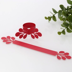 Macro detail of red laser-cut paper napkin rings with delicate lace floral pattern