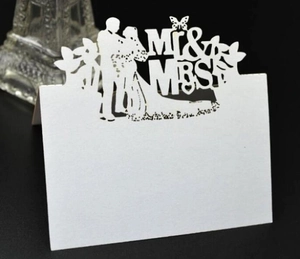Detail view of laser-cut white wedding place card with Mr & Mrs silhouette design