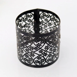 Detail of laser-cut black metal napkin ring with heart and floral pattern