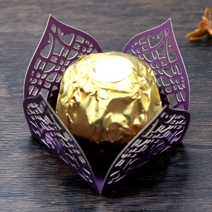 Close-up of laser-cut purple paper truffle wrapper with golden chocolate detail