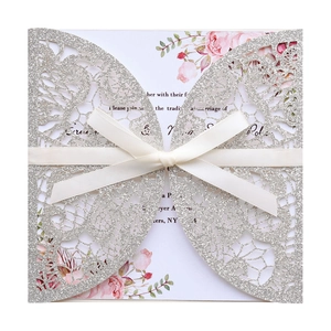 Lasercut-Hochzeitseinladung aus silbernem Glitzerpapier mit Schleife und Blumenkarte