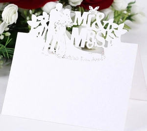 Laser cut white Mr & Mrs wedding place card with butterfly and silhouette on table